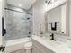 Stylish bathroom features tiled shower/tub, marble vanity, and modern fixtures at 4314 Des Plaines Dr, Sarasota, FL 34233