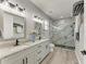 Modern primary bathroom with double sinks, a large shower with glass doors, and grey tiling at 4314 Des Plaines Dr, Sarasota, FL 34233