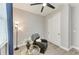 Cozy bedroom boasts wood-look floors, ceiling fan, chair, and window with blue curtains at 4314 Des Plaines Dr, Sarasota, FL 34233