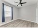 Bedroom features wood-look floors, a ceiling fan, a window, and neutral walls at 4314 Des Plaines Dr, Sarasota, FL 34233