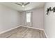 Neutral bedroom boasts gray walls, wood-look floors, ceiling fan, and bright window at 4314 Des Plaines Dr, Sarasota, FL 34233
