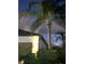 Exterior of house at night with palm trees illuminated by house lighting at 4314 Des Plaines Dr, Sarasota, FL 34233