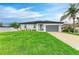 Charming one-story home with manicured lawn, gray garage door, and lush tropical landscaping at 4314 Des Plaines Dr, Sarasota, FL 34233