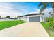 Charming one-story home with a well-manicured lawn and a long driveway leading to the garage at 4314 Des Plaines Dr, Sarasota, FL 34233