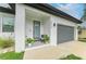 Inviting front porch with stylish decor, modern door, and a gray garage door nearby at 4314 Des Plaines Dr, Sarasota, FL 34233