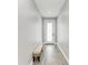 Bright hallway featuring wood-look flooring, white trim, a seating bench, and a modern door at 4314 Des Plaines Dr, Sarasota, FL 34233