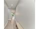 Bright hallway featuring wood-look flooring, white trim, a seating bench, and views of kitchen at 4314 Des Plaines Dr, Sarasota, FL 34233
