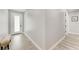 Bright hallway features a white front door, neutral walls, and wood-look flooring at 4314 Des Plaines Dr, Sarasota, FL 34233
