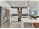Modern kitchen featuring white cabinets, stainless steel appliances, and stylish gray subway tile backsplash at 4314 Des Plaines Dr, Sarasota, FL 34233