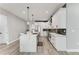 Modern kitchen with white cabinets, stainless steel appliances, stylish lighting, and a large kitchen island at 4314 Des Plaines Dr, Sarasota, FL 34233