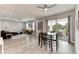 Open concept living and dining areas with stylish gray wood flooring and lots of natural light at 4314 Des Plaines Dr, Sarasota, FL 34233
