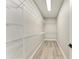 Walk-in closet with metal racks for shelving in a neutral color scheme with wood-look floors at 4314 Des Plaines Dr, Sarasota, FL 34233
