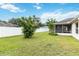 Spacious backyard featuring a lush lawn, mature tree, and a screened lanai at 4649 72Nd E Ct, Bradenton, FL 34203