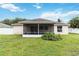 Spacious backyard with a screened patio, mature landscaping, and privacy fencing at 4649 72Nd E Ct, Bradenton, FL 34203