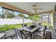 Covered patio with ceiling fan and dining table, perfect for outdoor entertaining with views of the backyard at 4649 72Nd E Ct, Bradenton, FL 34203