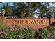 The Creekwood community sign is beautifully landscaped with colorful flowers, lighting, and brick walls at 4649 72Nd E Ct, Bradenton, FL 34203
