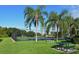 Outdoor tennis court surrounded by lush greenery and palm trees with picnic tables and benches on a sunny day at 4649 72Nd E Ct, Bradenton, FL 34203