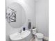 A half bathroom featuring pedestal sink, round mirror and tiled floors at 4654 Claremont Park Dr, Bradenton, FL 34211
