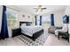 Spacious bedroom features a large bed, ceiling fan, and two windows with blue curtains at 4654 Claremont Park Dr, Bradenton, FL 34211