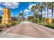 Elegant gated community entrance with manicured landscaping and brick-paved road lined with palm trees at 4654 Claremont Park Dr, Bradenton, FL 34211