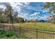 Expansive dog park featuring lush green grass, trees, and a secure metal fence in a pet-friendly community at 4654 Claremont Park Dr, Bradenton, FL 34211