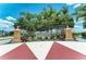 Community entrance featuring decorative columns, landscaping, and signage at 4654 Claremont Park Dr, Bradenton, FL 34211