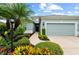 Front view of a one story home with a well-maintained lawn and colorful, professionally landscaped flowerbeds at 4654 Claremont Park Dr, Bradenton, FL 34211