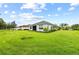 Back view of house showing neutral tones with well manicured lawn and garden beds at 4654 Claremont Park Dr, Bradenton, FL 34211
