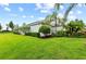 A house with a well-kept lawn, manicured bushes, and tropical palm trees at 4654 Claremont Park Dr, Bradenton, FL 34211