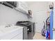 Laundry room with black washer and dryer plus storage shelving and utility sink at 4654 Claremont Park Dr, Bradenton, FL 34211