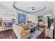 Expansive living area with hardwood floors, coffered ceiling, and open-concept design to kitchen and dining at 4654 Claremont Park Dr, Bradenton, FL 34211