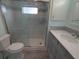 Updated bathroom with a marble-look shower, grey cabinets, and modern fixtures at 5112 Glen Echo Ave, Sarasota, FL 34234