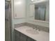 Updated bathroom with a gray vanity, white sink, and framed mirror at 5112 Glen Echo Ave, Sarasota, FL 34234