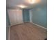 This blue bedroom features gray laminate flooring and a closet at 5112 Glen Echo Ave, Sarasota, FL 34234