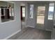 A view of the entranceway from the inside, showing a decorative window and gray wood-look floors at 5112 Glen Echo Ave, Sarasota, FL 34234
