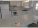 A well-lit kitchen with white cabinets, modern appliances, and counter seating for casual dining and entertaining at 5112 Glen Echo Ave, Sarasota, FL 34234