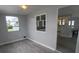 A light and airy living space with gray wood-look flooring and a partial view of the kitchen at 5112 Glen Echo Ave, Sarasota, FL 34234