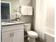 Clean bathroom with a single sink vanity, toilet, and shower-tub combination with white tile at 5812 Ocean Isle Dr, Nokomis, FL 34275