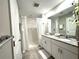 Bathroom featuring dual sinks, granite countertops, and a shower with white shower curtain at 5812 Ocean Isle Dr, Nokomis, FL 34275