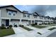 Street view of beige two-story townhomes with garages and blue doors at 5812 Ocean Isle Dr, Nokomis, FL 34275