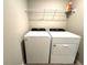 Bright laundry room featuring a white Whirlpool washer and dryer and a wire rack for extra storage at 5812 Ocean Isle Dr, Nokomis, FL 34275