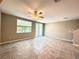 Bright living room with tile flooring, a ceiling fan, and a sliding glass door to the outdoor patio at 5812 Ocean Isle Dr, Nokomis, FL 34275