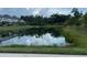 Scenic view of a calm pond reflecting trees and a nearby building at 5812 Ocean Isle Dr, Nokomis, FL 34275