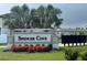 Community sign for Spencer Cove, landscaped with green grass and colorful red flowers at 5812 Ocean Isle Dr, Nokomis, FL 34275