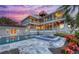 Stunning backyard oasis featuring a sparkling pool, hot tub, and vibrant landscaping, perfect for relaxation and entertainment at 585 Gunwale Ln, Longboat Key, FL 34228