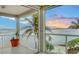 Balcony with white railings, tiled floors, potted plants, and views of water and sunset at 585 Gunwale Ln, Longboat Key, FL 34228