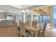 Waterfront dining area with views from every angle, bathed in natural light through walls of windows and glass doors at 585 Gunwale Ln, Longboat Key, FL 34228