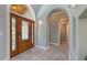 Grand foyer showcasing a decorative wood door, arched doorway, and neutral tile flooring for a sophisticated welcome at 585 Gunwale Ln, Longboat Key, FL 34228