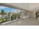 Spacious living room with tiled floors and large windows showcasing the exterior pool and landscaping at 585 Gunwale Ln, Longboat Key, FL 34228