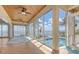 Sun room boasting walls of windows, wood ceiling, and views of the pool and ocean waters at 585 Gunwale Ln, Longboat Key, FL 34228